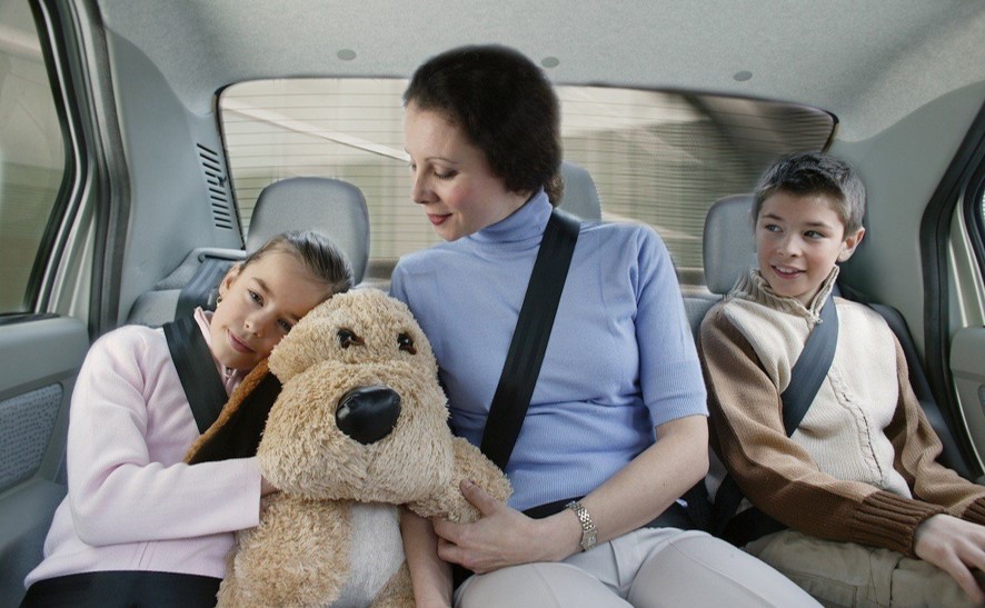 madre e hijos en asientos traseros de auto